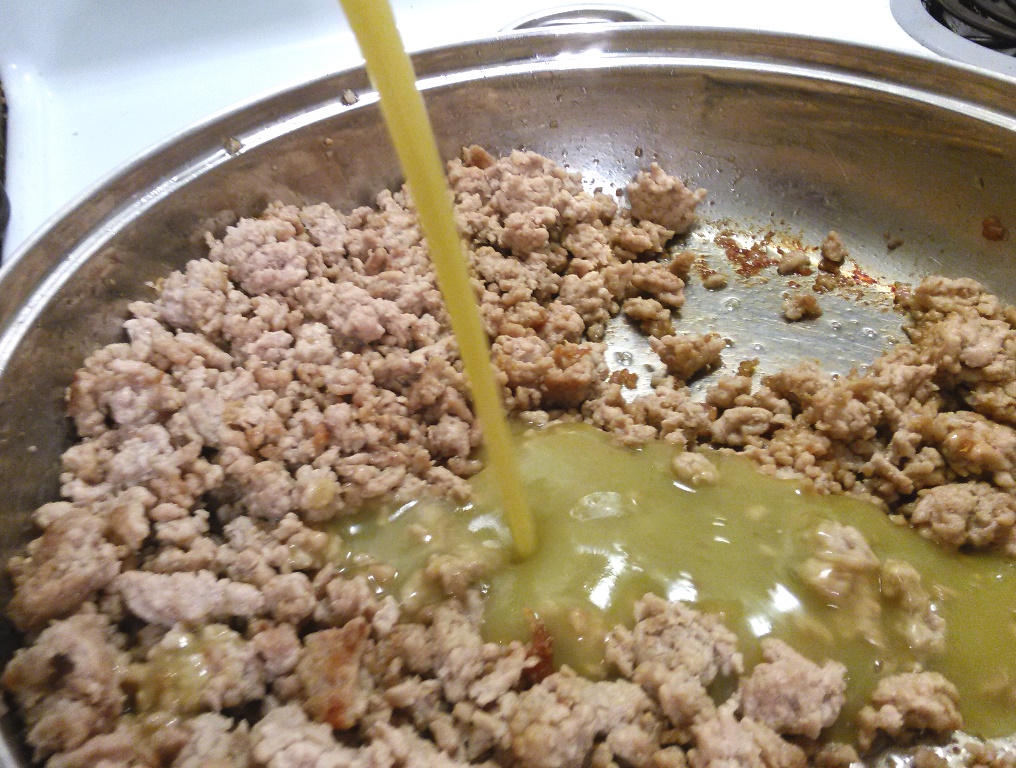 Add about one-third of a 26 ounce can of green chile sauce to the meat. 