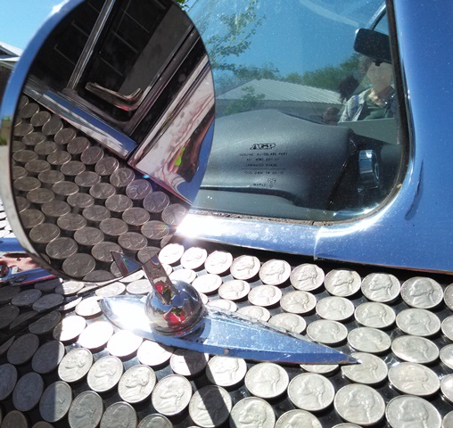 A car parked out front is covered entirely with pennies and nickels. 