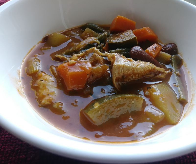 Closeup view of chicken minestrone in a white bowl. 